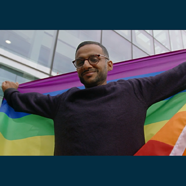 ServiceNow employee Sumit B. holding a Pride flag