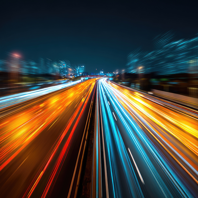 Streaking blurry car headlights on a busy highway at night