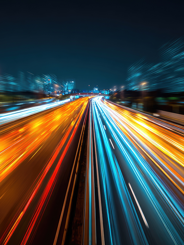 Streaking blurry car headlights on a busy highway at night