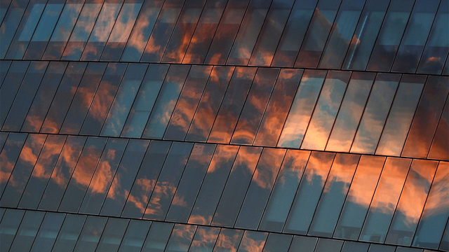 Architecture of glass building with reflection of sky sunset